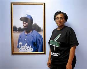 Valerie Bell beside a portrait of her son Sean who was gunned down by cops on his wedding day