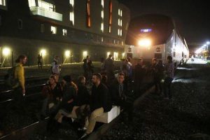 Demonstrators sit on a railroad track in front of an Amtrak train during a march against the New York City grand jury decision to not indict in the death of Eric Garner in Berkeley, California December 8, 2014. REUTERS/Stephen Lam