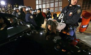 New York City police arrest a young woman on a shutdown portion of the Westside Highway during a protest against the decision of a grand jury not to indict a police officer involved in the death of Eric Garner in New York, New York, December 3, 2014. (EPA/PETER FOLEY) 