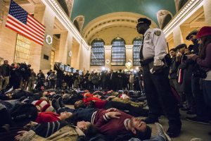 A police officer stands over activists, demanding justice for the death of Eric Garner, as they stage a 'die-in' during rush hour at Grand Central Terminal in the Manhattan borough of New York on December 3, 2014. (REUTERS/Adrees Latif) 