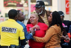 A distraught woman is comforted outside the food court entrance to the Oakwood Center in the New Orleans suburb of Gretna, La., on Wednesday.