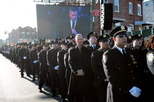 Cops turn away from Mayor de Blasio as he speaks at the funeral