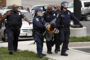 Baltimore Police officers arrest a man following the funeral of Freddie Gray near Mowdamin Mall