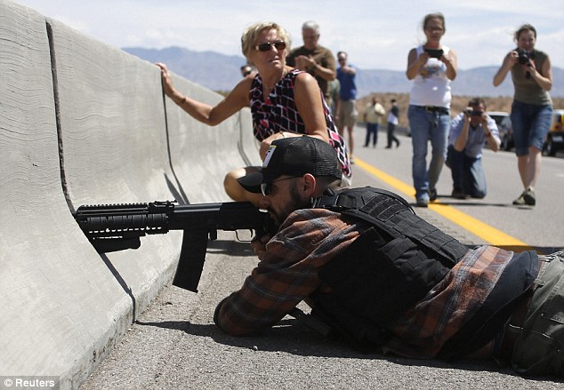 Firepower: Protester Eric Parker from central Idaho aims his weapon from a bridge next to the Bureau of Land Management's base camp where seized cattle Read more: http://www.dailymail.co.uk/news/article-2603026/Senator-speaks-favor-Nevada-rancher-militias-join-battle-federal-agents-accused-acting-like-theyre-Tienanmen-Square-fight-disputed-ranch-land.html#ixzz3YiApdyRN  Follow us: @MailOnline on Twitter | DailyMail on Facebook