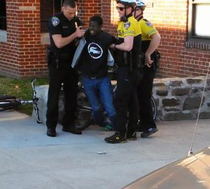 Freddie Gray is pictured being arrested by Baltimore police on April 12. Later, Gray can be seen being dragged by the cops into the van, and it seems as though he was already unable to walk.