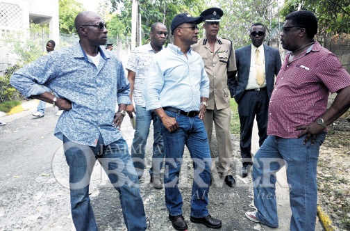 Security Minister Peter Bunting (centre) in discussion with Rev Knollis King (right), councillor for the Rose Heights Division, St James at the spot where two people were murdered Thursday night. The security minister toured the parish following six murders between Thursday night and yesterday morning. Assistant Commissioner of Police Paul Ferguson (third right), was among members of the minister’s touring party. (PHOTO: ANTHONY LEWIS)