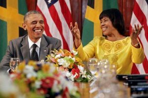 U.S. President Barack Obama (L) smiles during remarks by Jamaica's Prime Minister Portia Simpson-Miller after their meeting at Jamaica House in Kingston April 9, 2015. REUTERS/Jonathan Ernst