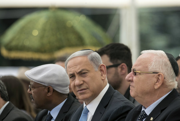 Israeli Prime Minister Benjamin Netanyahu, center, and President Reuven Rivlin, right, attend a ceremony on Mount Herzl in Jerusalem commemorating Ethiopians that died during their immigration to Israel, Sunday, May 17, 2015. Many of the 135,000 members of the Ethiopian community were brought to Israel on secret flights in the mid-1980s and early 1990s. (AP Photo/Baz Ratner, Pool)