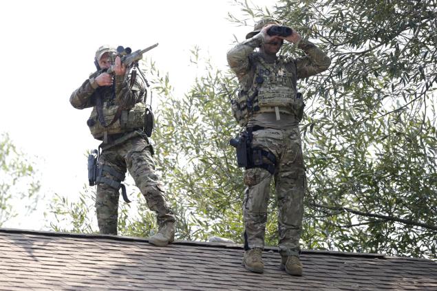 Sept. 1, 2015 - Fox Lake, IL, USA - A sniper and a lookout stand on top of a roof searching for two men following the killing of a police officer Tuesday, Sept. 1, 2015 in Fox Lake, Ill. (Credit Image: © Stacey Wescott/TNS via ZUMA Wire)