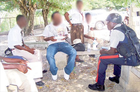 A policeman engages students of Central High School in May Pen as part of community policing efforts.