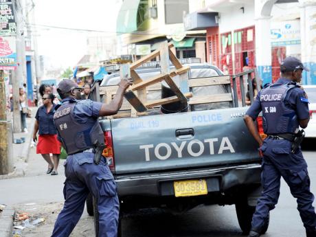 Police remove vendors from streets downtown Kingston..