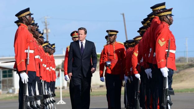 David Cameron was greeted by an honour guard and national anthems at the airport in Kingston