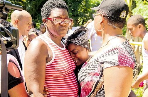 A grief-stricken relative of the victims of Thursday’s deadly attack in Campbellton, Hanover, has to be consoled by residents.