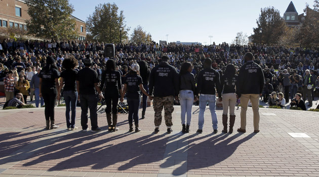 Members of black student protest group Concerned Student 1950 hold hands following the announcement that University of Missouri System President Tim Wolfe would resign Monday, Nov. 9, 2015, at the university in Columbia, Mo. Wolfe resigned Monday with the football team and others on campus in open revolt over his handling of racial tensions at the school. (AP Photo/Jeff Roberson)