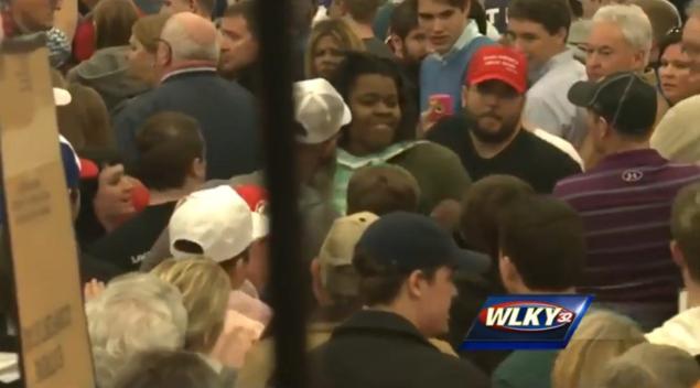 A man wearing a make America great again hat — thought to be Matthew Heimbach, a leader of the Traditionalist Worker Party — can be seen next to a protestor at the Trump rally in Louisville.