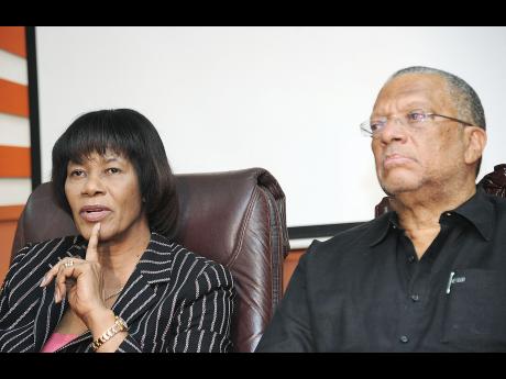 Opposition Leader Portia Simpson Miller and Dr Peter Phillips, opposition spokesman on finance, address members of the media during a press conference hosted by the People’s National Party at its Old Hope Road, St Andrew headquarters yesterday. 