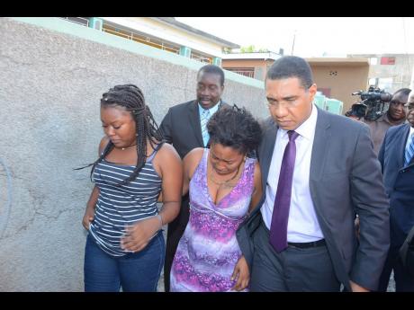 Prime Minister Andrew Holness and National Security Minister Robert Montague on Monday visited Bryden Street in east Kingston to meet the relatives of slain Woman Corporal Judith Williams. (Jamaica Star picture)