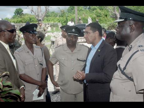 Police Commissioner Dr Carl Williams (left); Deputy Superintendent of Police (DSP) Clinton Moore (second left), the officer in charge of the Montego Hills police station; DSP Marlon Nesbeth (centre), the commanding officer for St James; and Assistant Commissioner of Police Warren Clarke (right) in dialogue with Prime Minister Andrew Holness during his tour of crime-plagued Montego Bay, St James, yesterday. Gleaner photo.